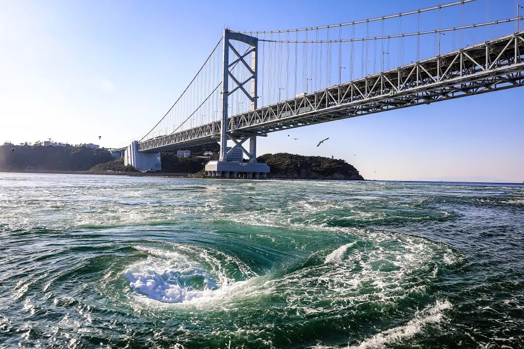 Naruto whirlpools seen from the Uzu-no-Michi glass floor walkway — large spiral formations in the Naruto Strait, the tidal phenomenon that names the Uzumaki clan
