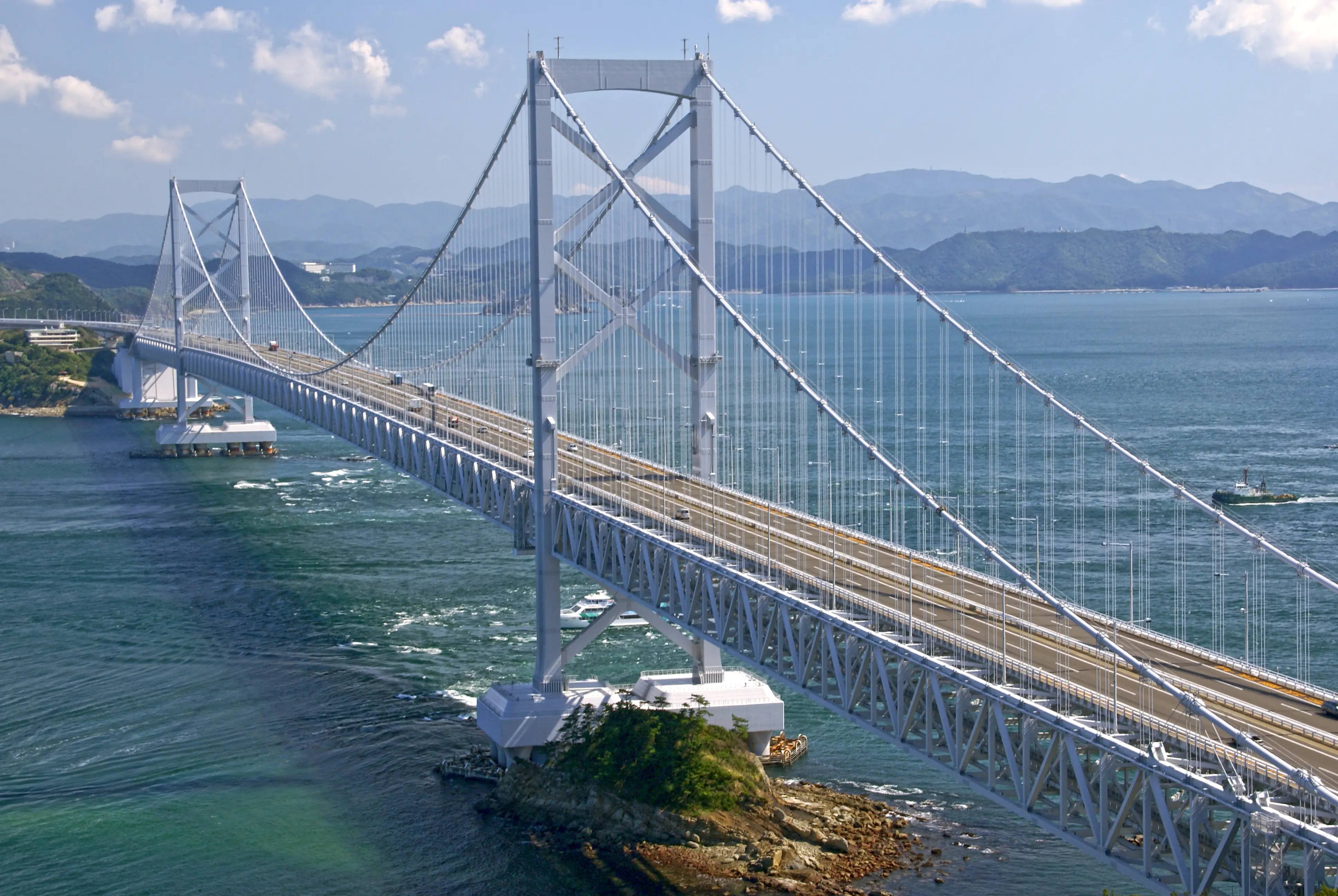 Onaruto Bridge spanning 1,629 meters across the Naruto Strait between Awaji Island and Shikoku at dusk — the bridge whose city gives Uzumaki Naruto his name