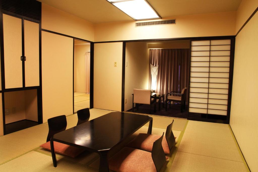 AoAwo Naruto Resort — traditional ryokan-style room with tatami mats, zaisu chairs, and a separate seating area by the window.