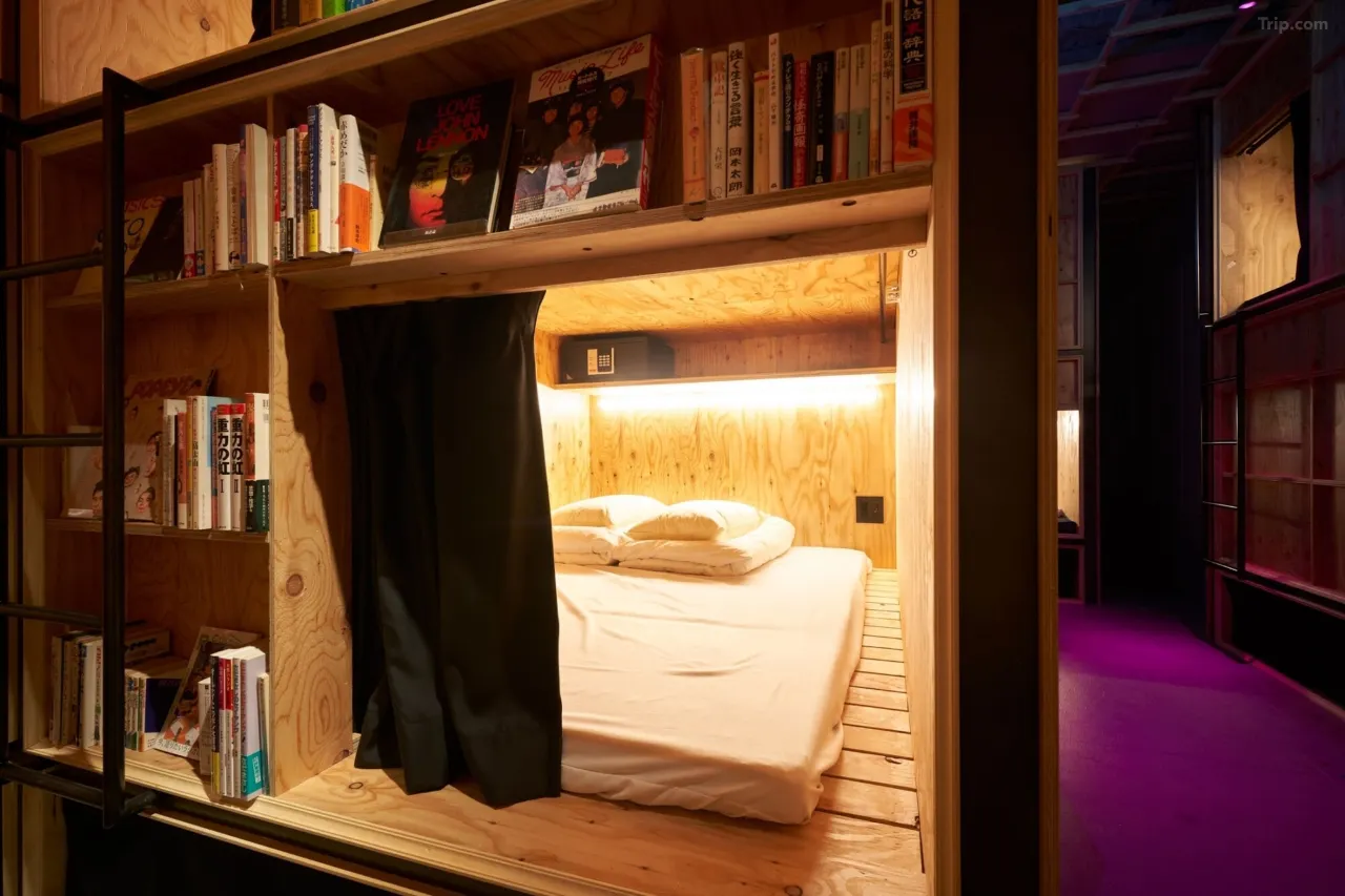 Floor-to-ceiling bookshelves with beds tucked inside at Book and Bed Tokyo