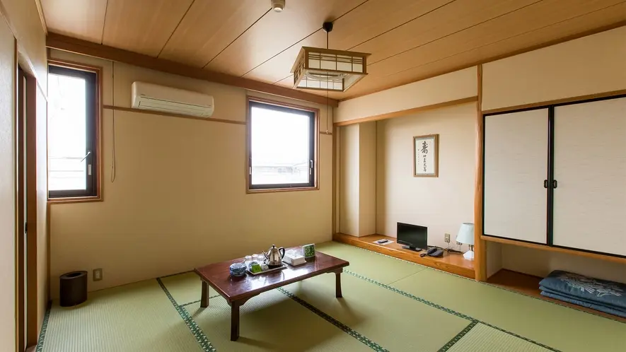 Business Hotel Pocket — traditional Japanese-style washitsu room featuring tatami mat flooring, a low chabudai table with tea service, and shoji paper doors in Matsushige, Tokushima. | Hotel Manga