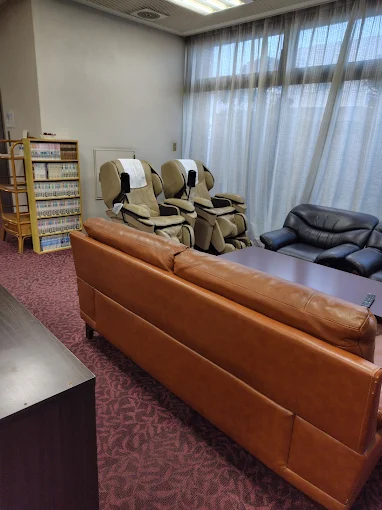 Business Hotel Pocket — relaxing guest lounge equipped with electric massage chairs, leather sofas, and a curated manga corner for travelers in Matsushige, Tokushima. | Hotel Manga