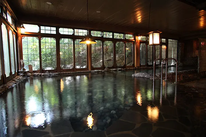Daimaru Besso 大丸別荘 — traditional Japanese stroll garden in autumn, with maple trees reflected in stone-edged pond. | Hotel Manga