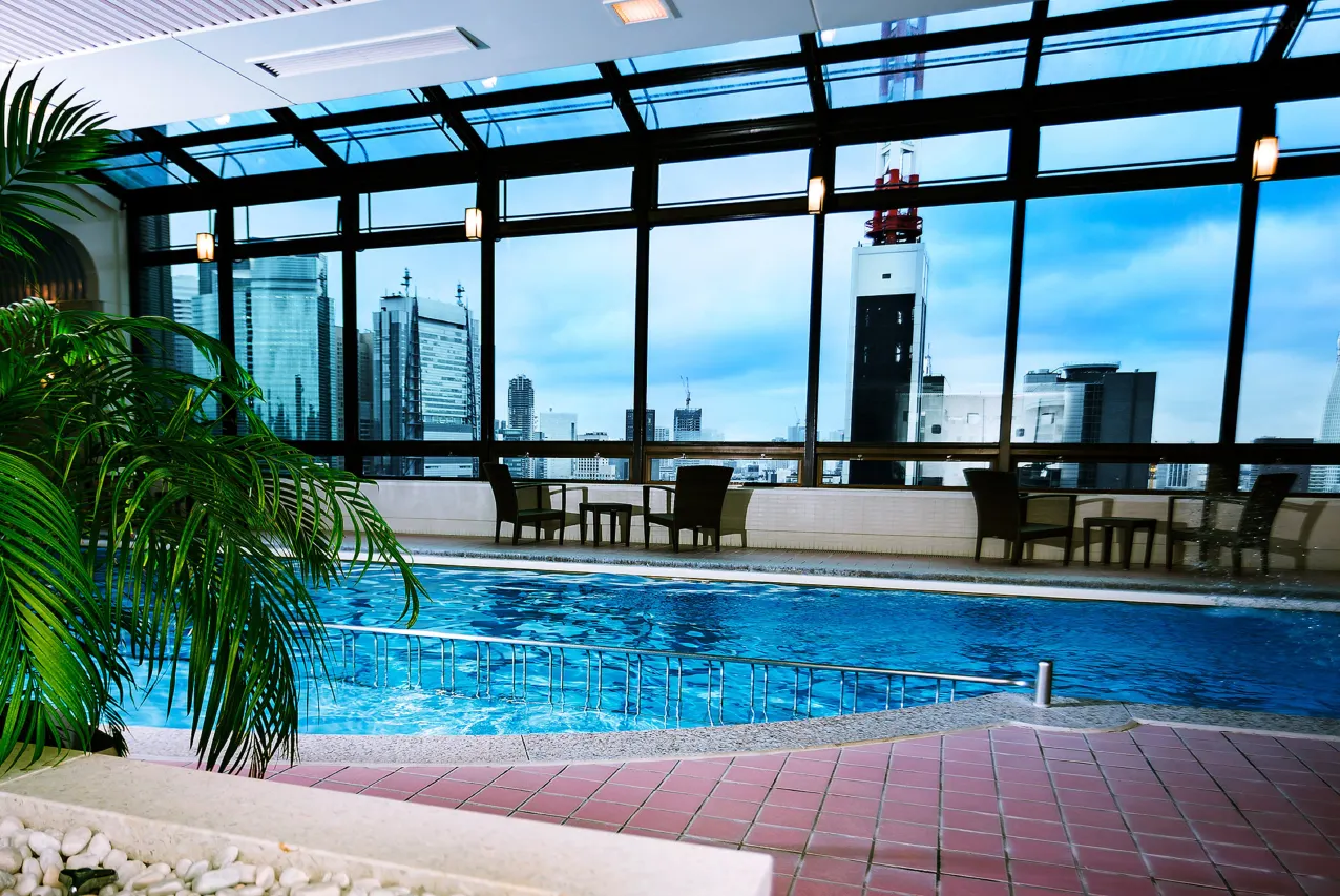 Imperial Hotel Tokyo — Rooftop Pool; Relax in the pool and spa, featuring a panoramic view of the Tokyo skyline and Tokyo Tower from the glass roof and windows. Book your relaxing stay at Imperial Hotel Tokyo