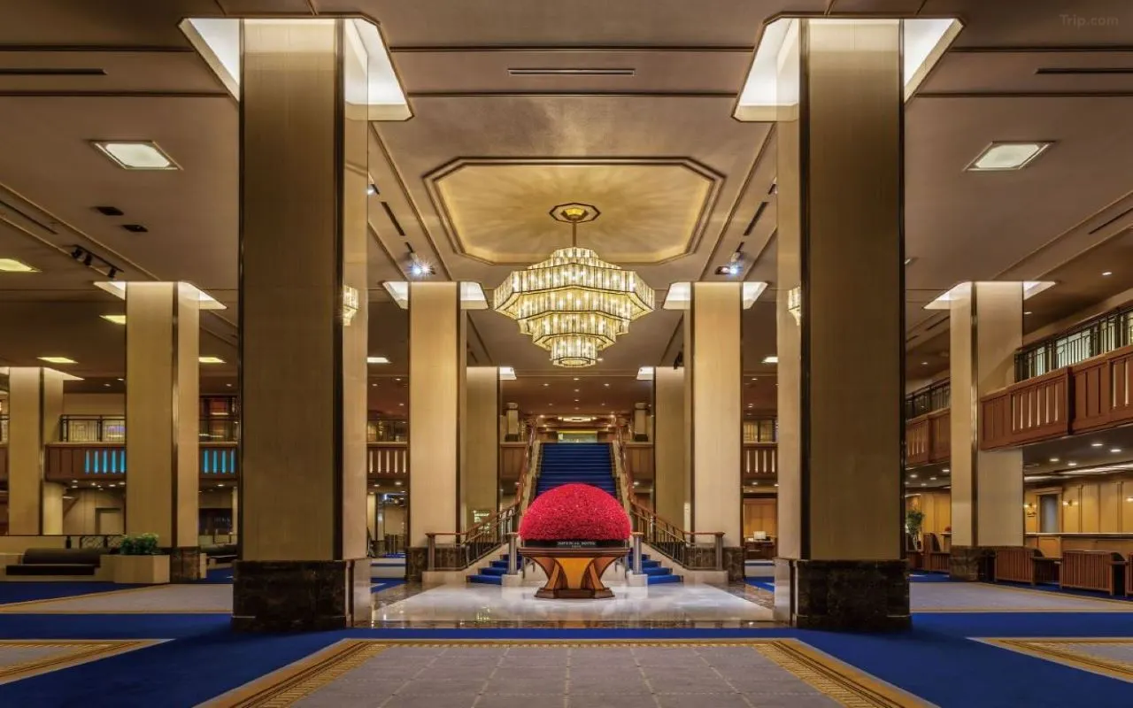 Imperial Hotel Tokyo — grand two-storey main lobby with monumental floral arrangements, Hibiya Park visible beyond