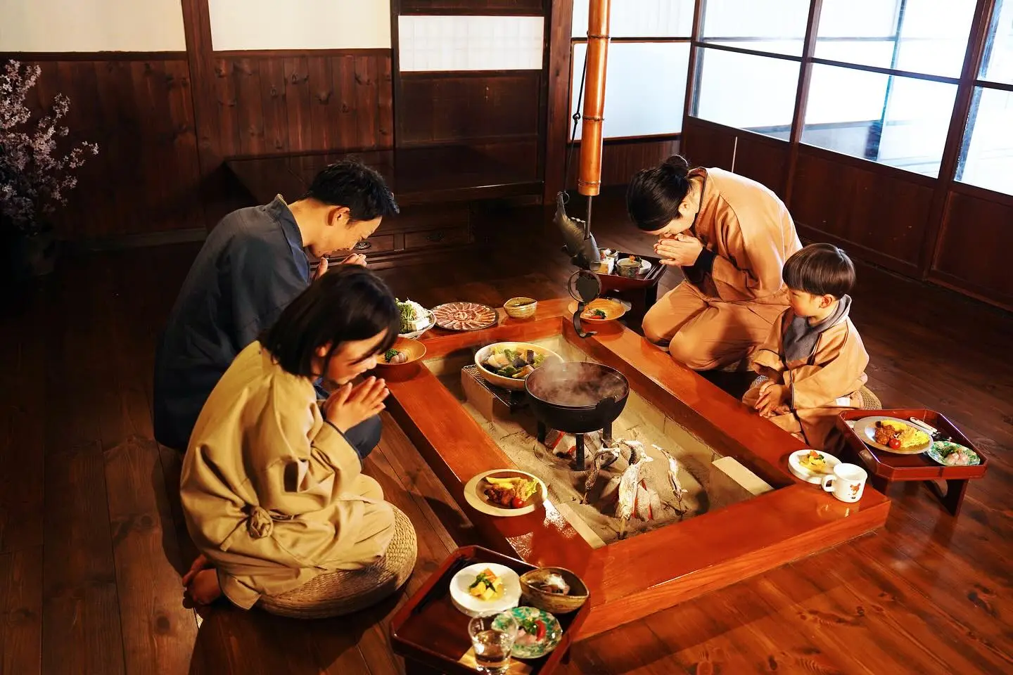Irori hearth at Magokoro — open kitchen with smoke-blackened beams, chef cooking gibier and river fish