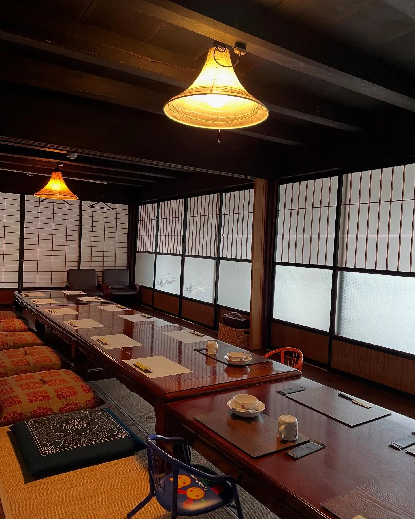 Kamado wood-fired stove at Magokoro — three-hole earthen stove in tile-floor kitchen, cooking rice from firewood