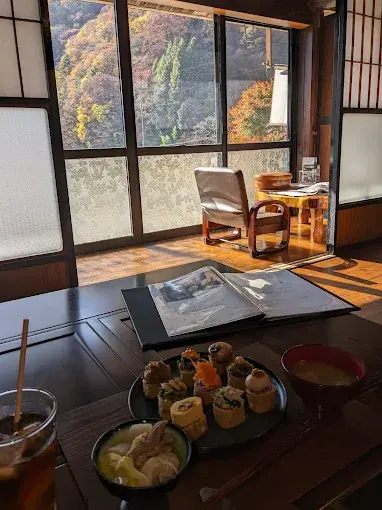 Sitting room veranda at Magokoro — original Showa frosted glass doors overlooking Southern Alps valley, Kamimura Iida