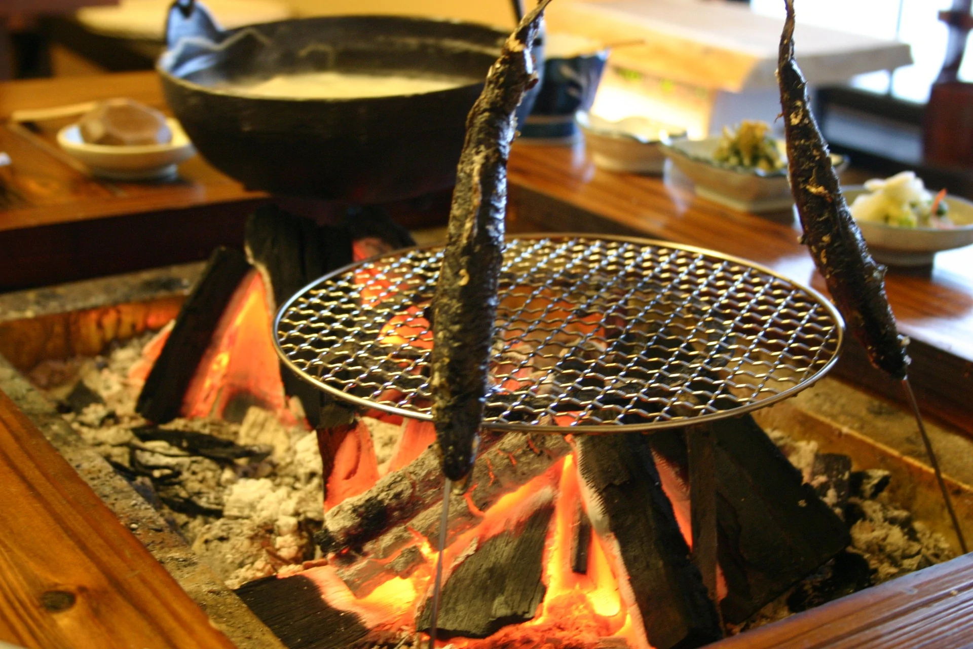 Irori hearth dinner at Sankosou Nukabira Onsen — yamame trout skewers, Ezo deer stone-grilled, mountain vegetables Hokkaido ryokan