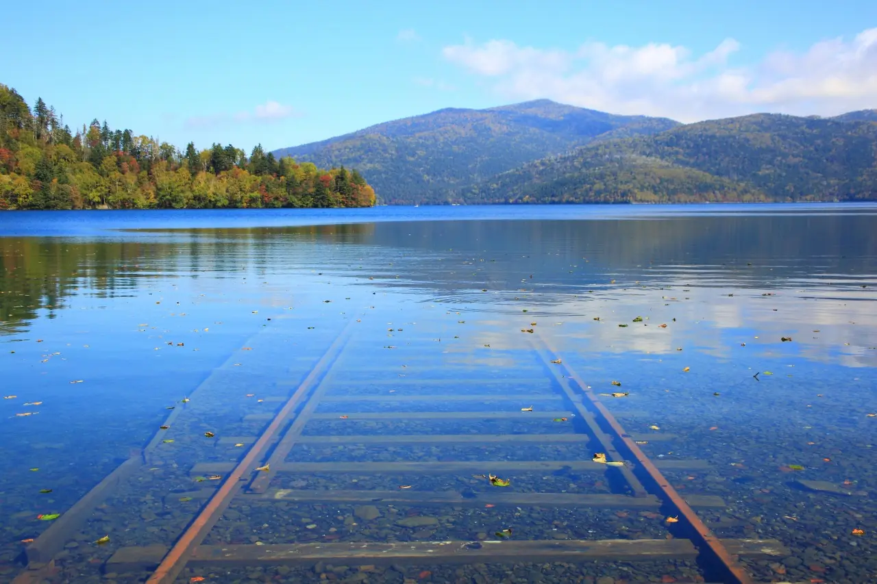 Lake Shikaribetsu Hokkaido submerged railway tracks Spirited Away — tracks disappearing into transparent lakebed