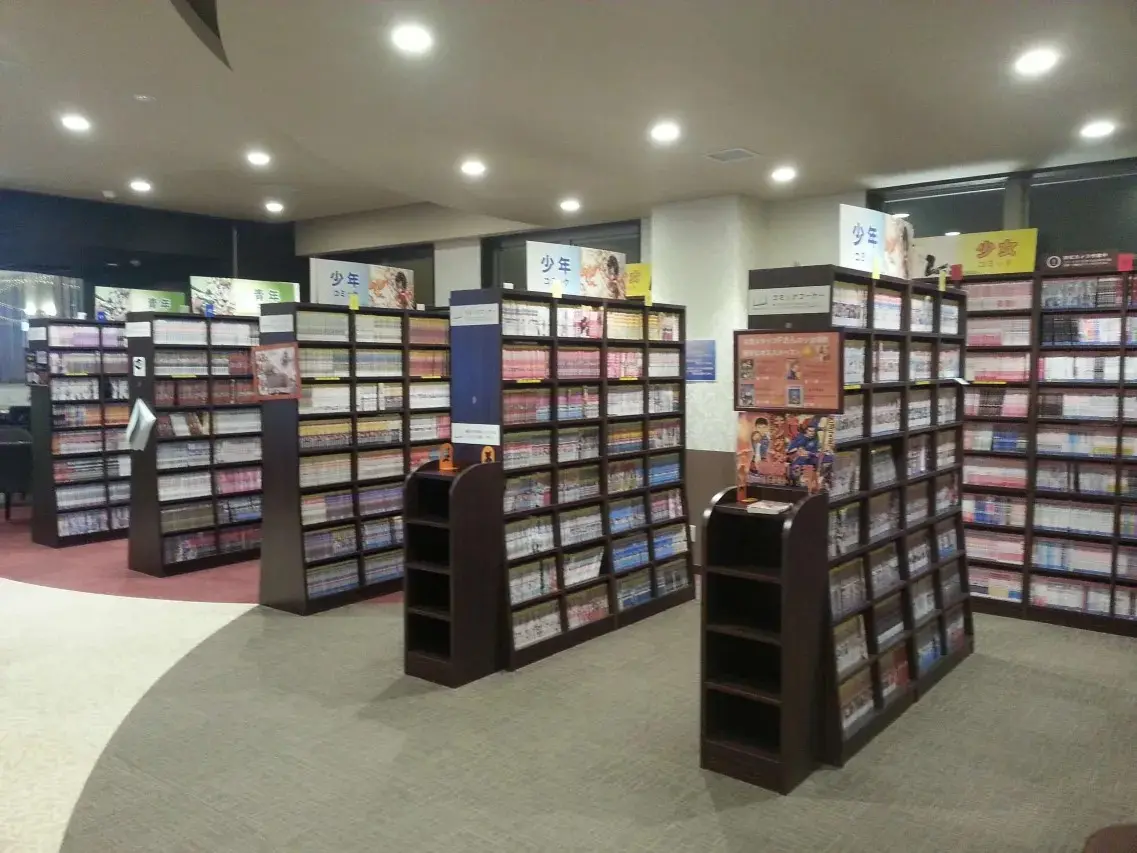 Teriha Spa Resort 照葉スパリゾート — third-floor Comic Corner with floor-to-ceiling shelving holding 30,000 manga volumes and recliner seating area with individual tablet screens in Fukuoka Island City. | Hotel Manga