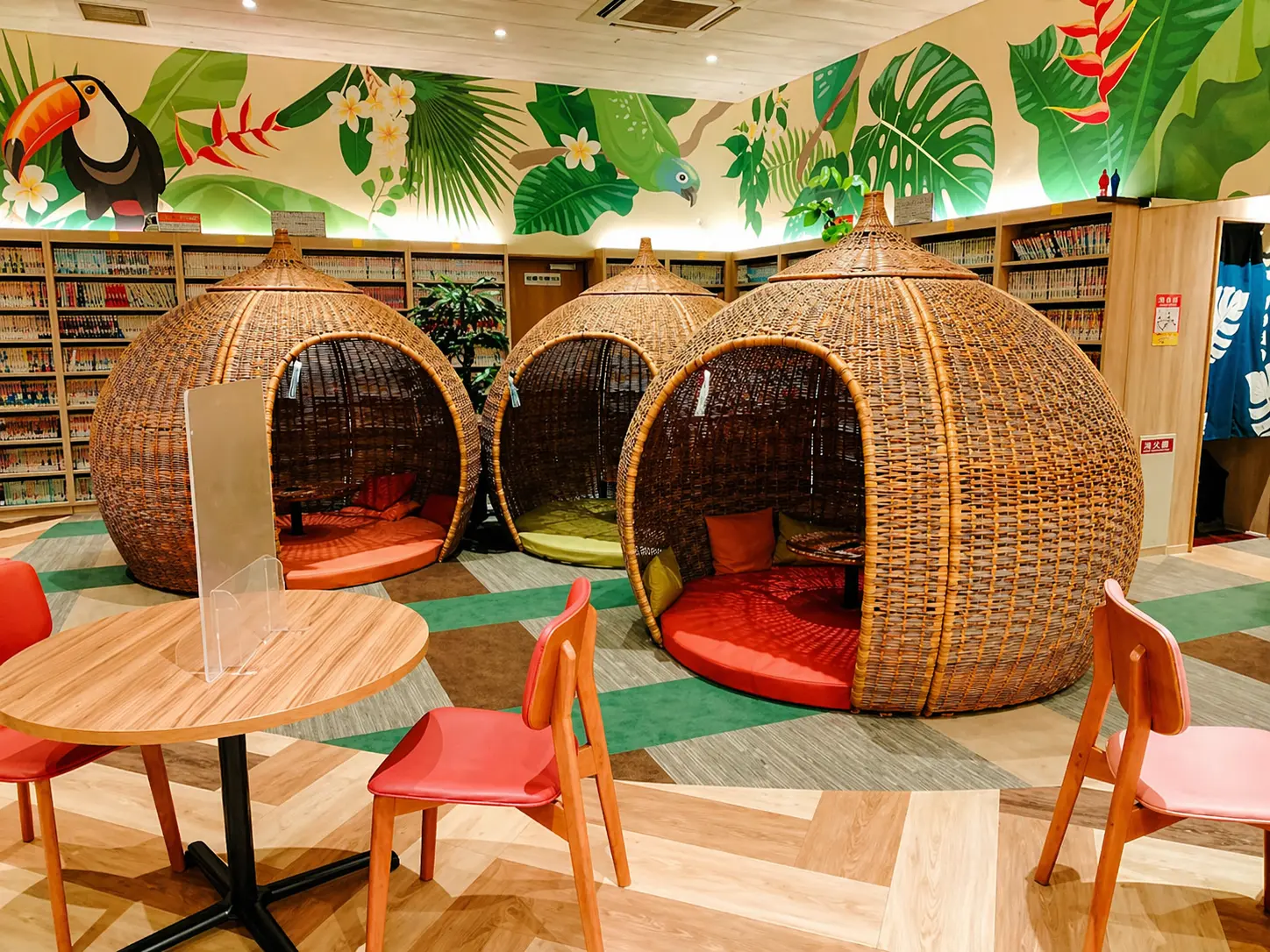 Teriha Spa Resort 照葉スパリゾート — unique relaxation lounge featuring wicker dome chairs and tropical wall art in a cozy comic book library setting. | Hotel Manga