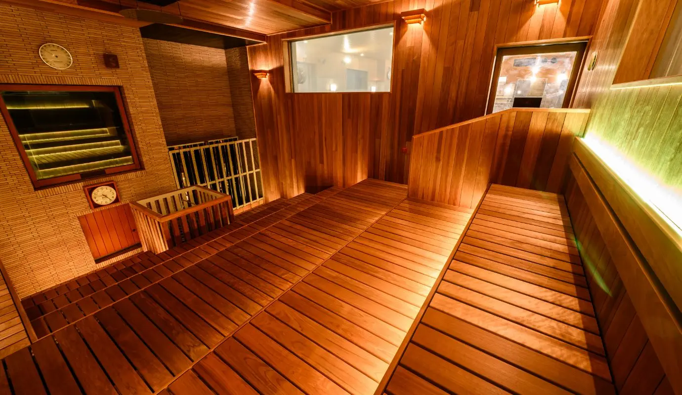 Teriha Spa Resort 照葉スパリゾート — expansive multi-level wooden sauna room with warm ambient lighting and temperature gauges for a premium spa experience. | Hotel Manga